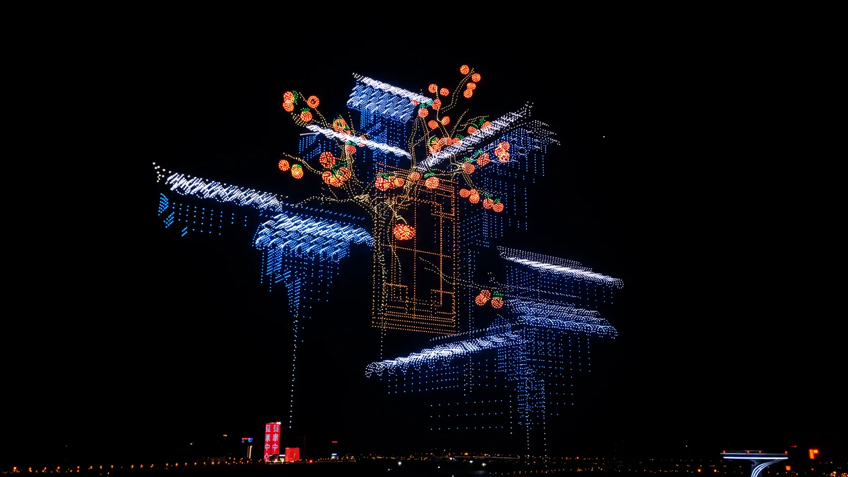 Formación de drones con forma de árbol en flor sobre un pabellón, alternativa visual a los fuegos artificiales